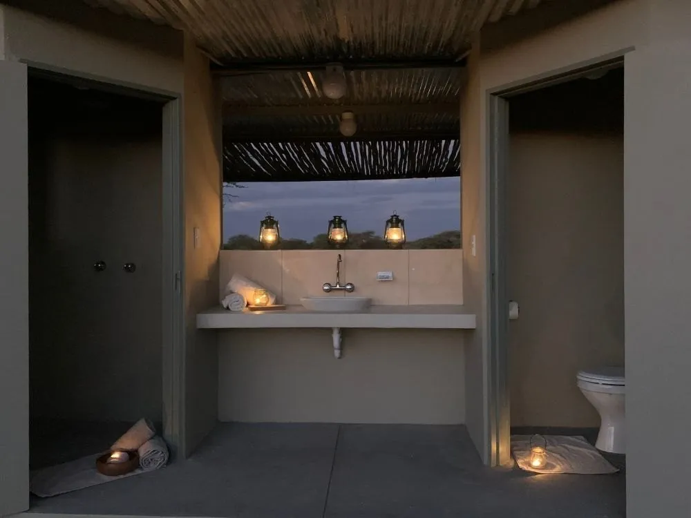 Private shower and toilet at a Yaguma campsite, lit with lanterns