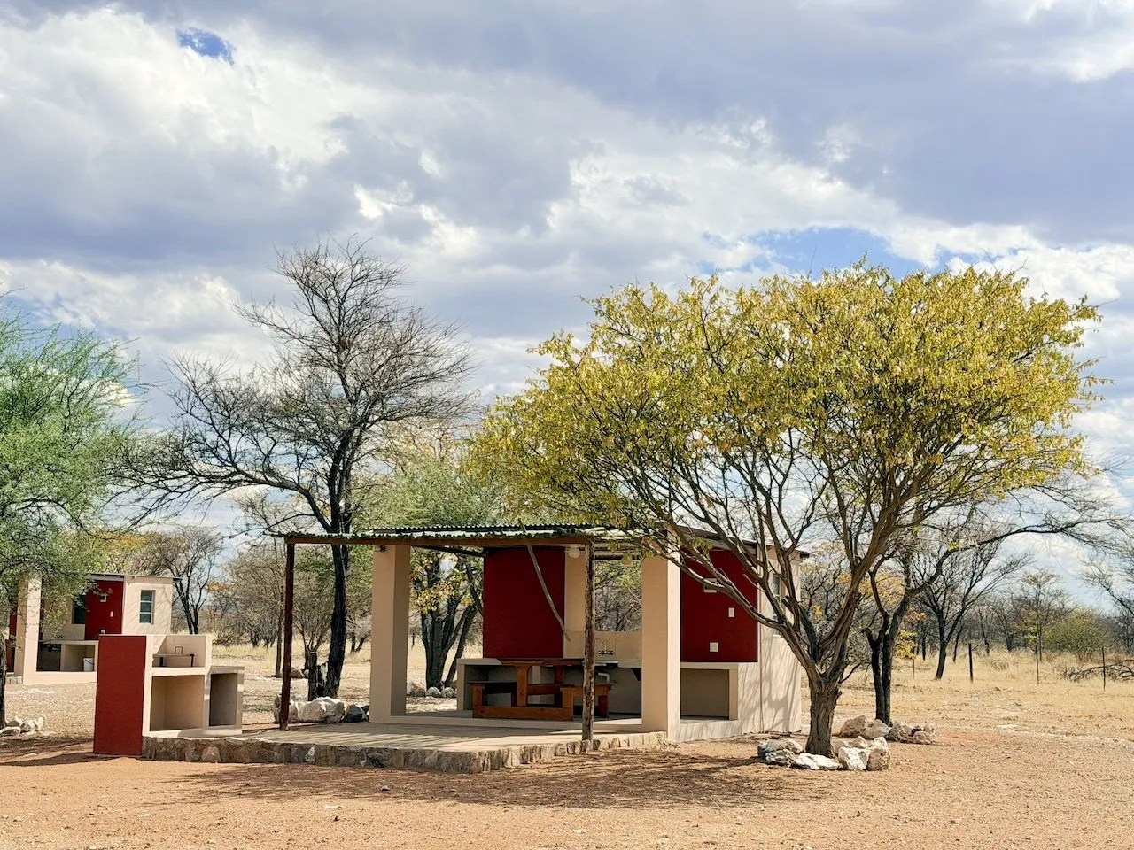 Private campsite with a shaded shelter and braai under trees near Etosha
